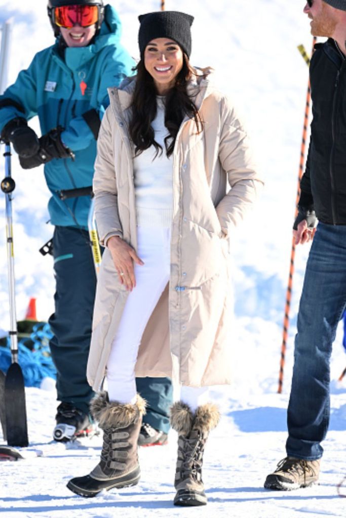 Meghan Markle wearing a puffer coat on the snow while skiing