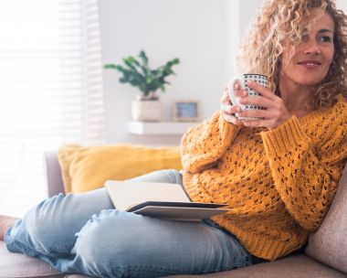 Woman reading book with cup of tea.