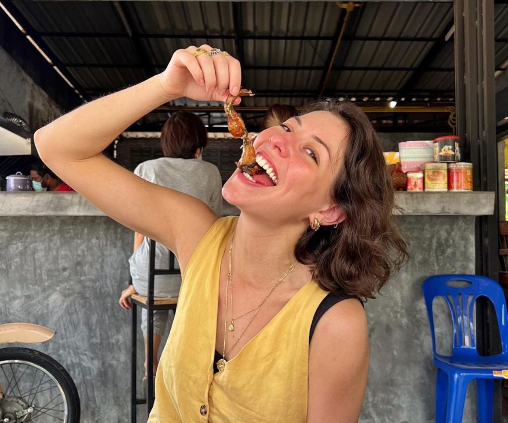 masterchef judge sofia is cute eating food in a yellow top, smiling