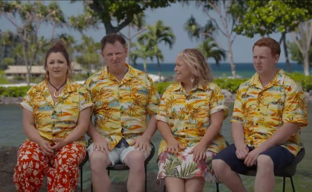 Travel Guides cast sit in tropical shirts in front of ocean