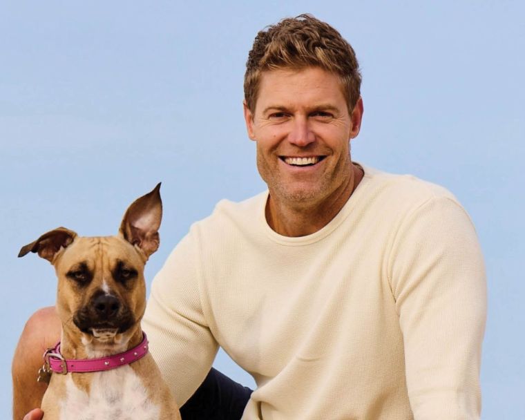 Dr Chris in white sweater with dog