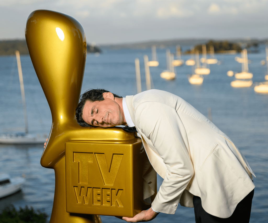 Andy Lee hugging the big TV WEEK Logie Award. 