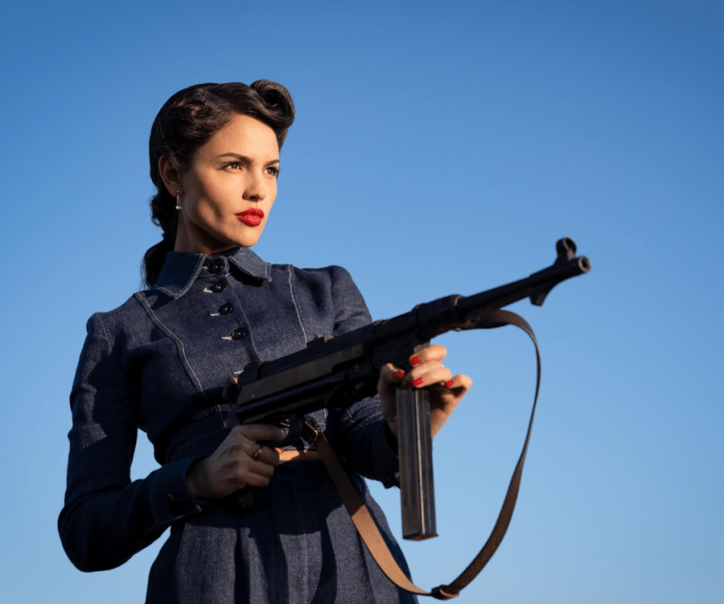 Eiza Gonzalex holding a gun in The Ministry of Ungentlemanly Warfare.